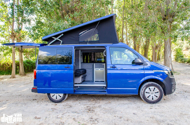 Vista lateral de una Volkswagen T6.1 Caravelle con techo elevable BRAM abierto, mostrando la estructura elevada y la lona del techo.