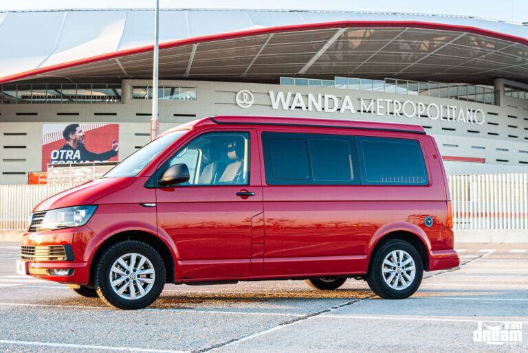 Vista lateral de una Volkswagen T6 Multivan roja con techo elevable Reimo cerrado, integrado en la línea original de la carrocería.