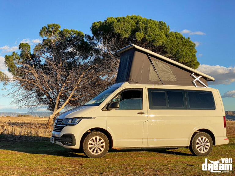 Vista exterior lateral de una Volkswagen T6 Multivan con techo elevable Atlas Camper abierto, mostrando su estructura elevada sobre la carrocería.