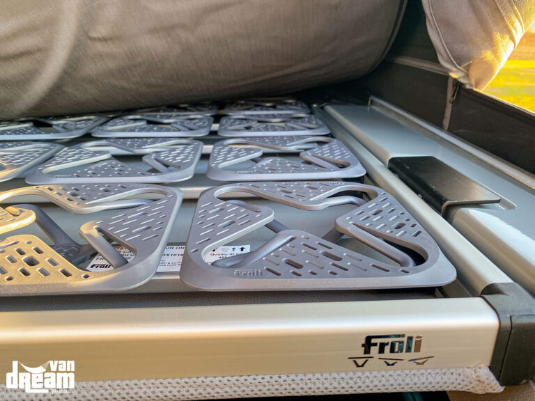 Detalle del somier Froli de aluminio de gama alta instalado en la cama superior del techo elevable Atlas Camper de una Volkswagen T6 Multivan.
